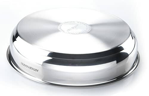 Couvercle en acier inoxydable sur une surface blanche.